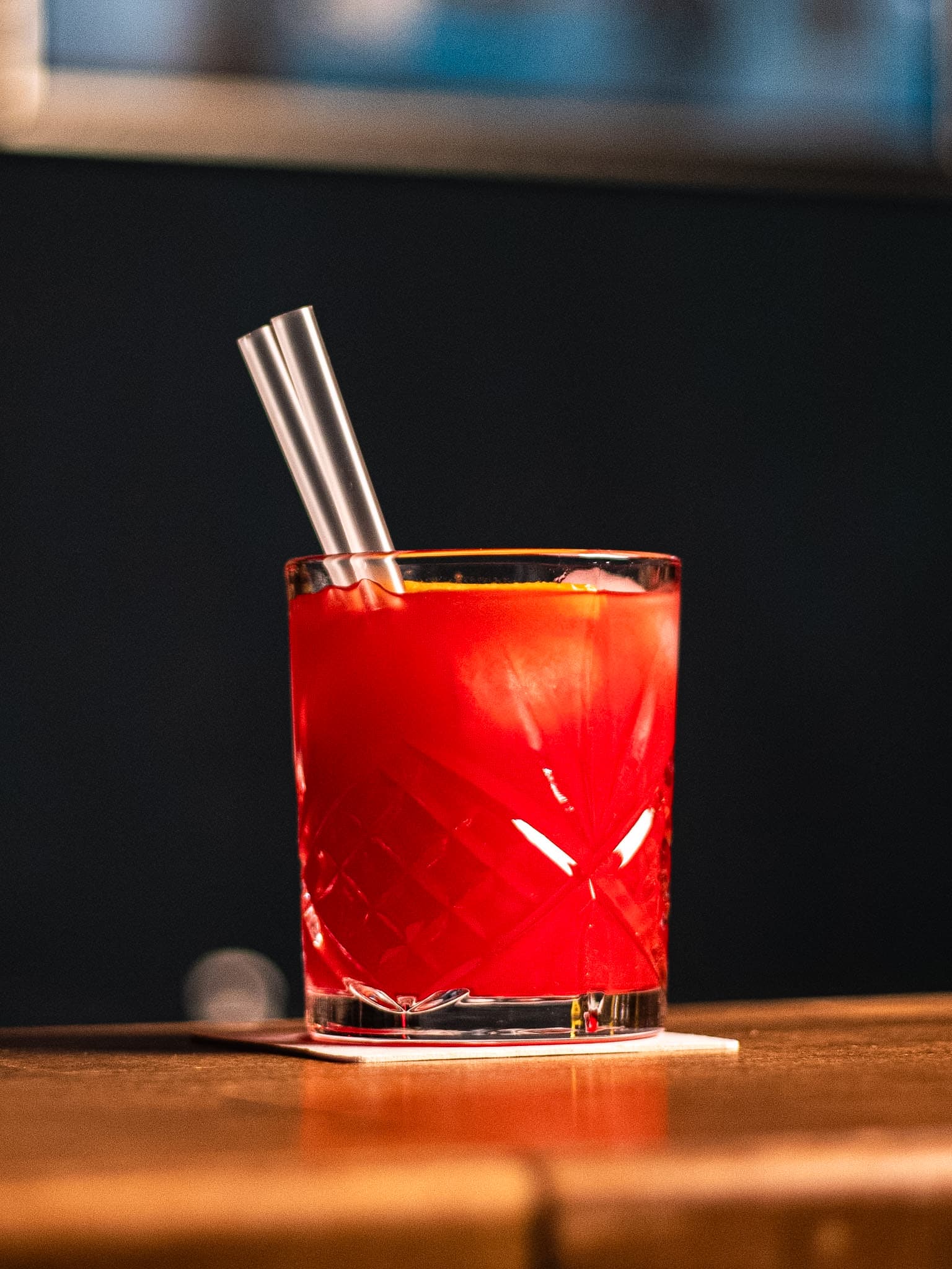 Signature Beetroot cocktail in faceted crystal glass on wooden counter